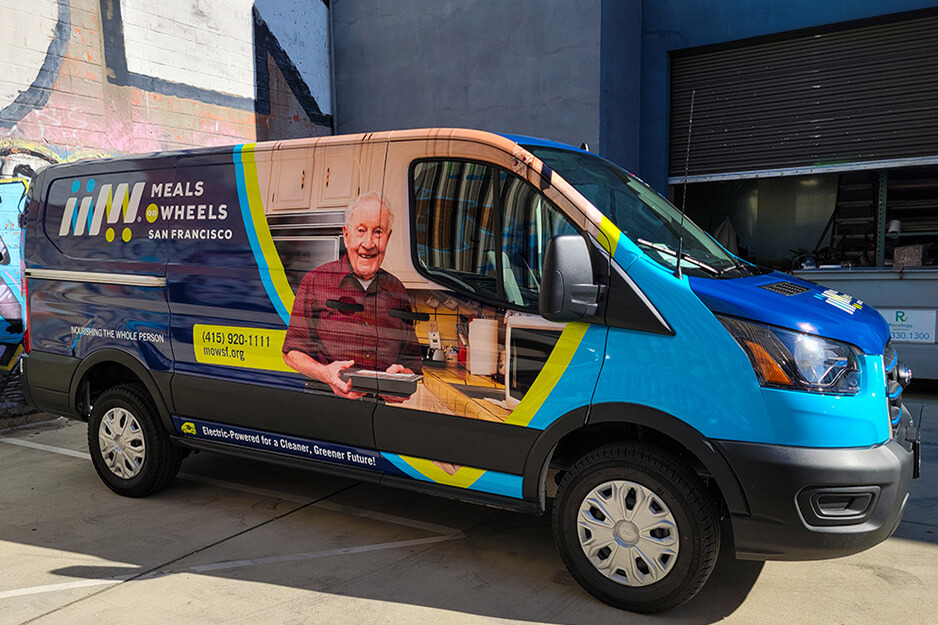 Meals on Wheels van with colorful graphics featuring older male client